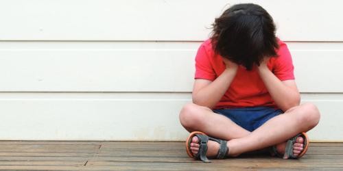 child with head in their hands