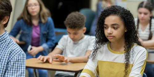 A student sitting in class looking upset