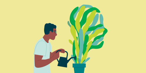 A person watering a plant that is the shape of a person's head